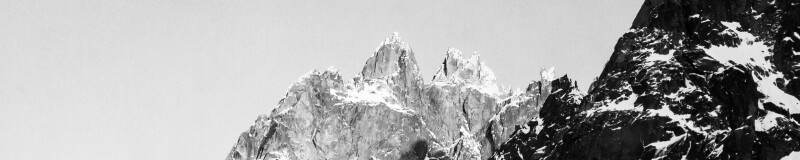 Black and white image of craggy mountains with dustings of snow