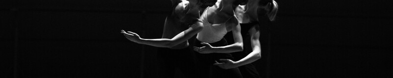 Black and white image of three dancers holding a pose