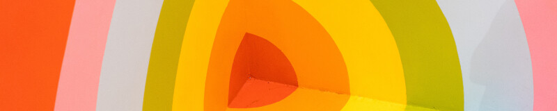 Colourful concentric circles painted on corner of a room