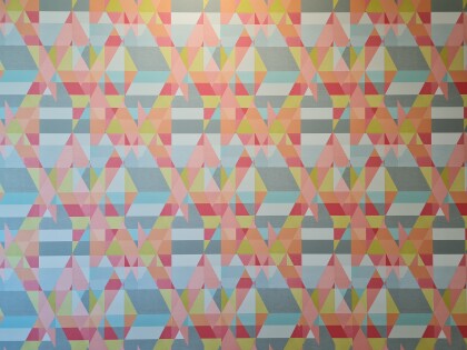 Geometric-patterned wallpaper, in red, orange, grey, white, black hues