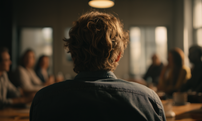 A view of a meeting looking over the shoulders of an individual at the head of the table