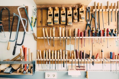 Wall of a woodworking workshop showing a variety of woodworking tools hanging on the wall