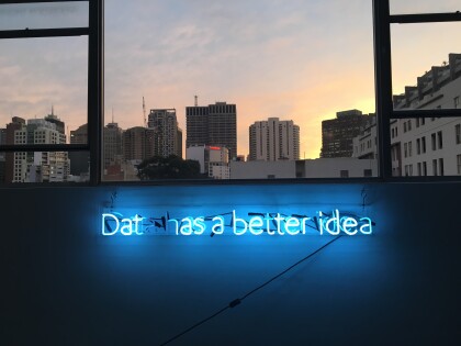 Twilight skyline with blue neon sign “data has a better idea”