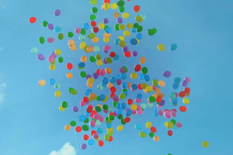 Coloured balloons floating in a blue sky