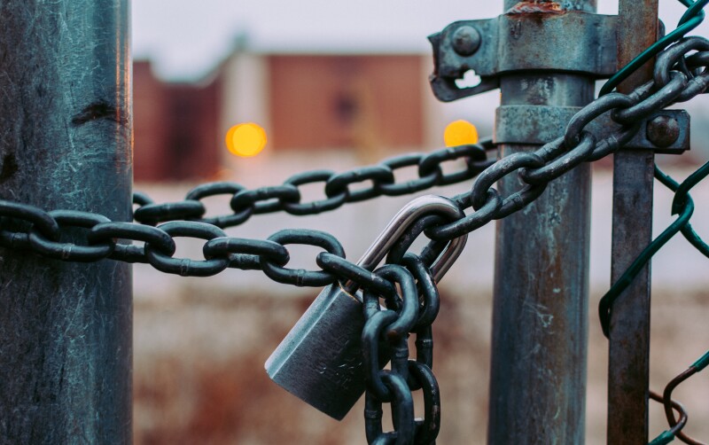 Padlocked chain on a wire fence