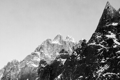 Black and white image of craggy mountains with dustings of snow