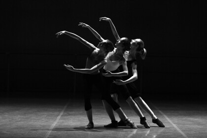 Black and white image of three dancers holding a pose