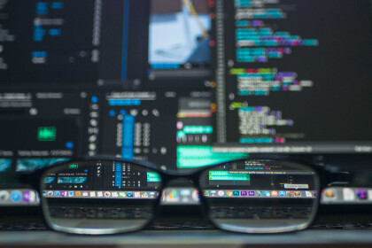 Glasses on laptop, screen blurred except through lenses