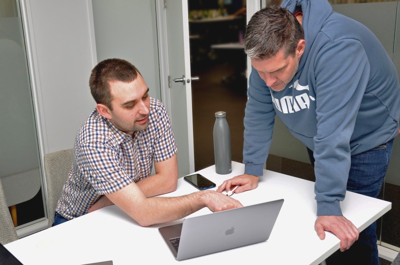 Two people discussing something on a laptop