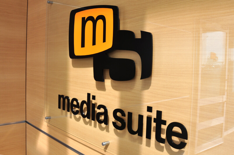 Media Suite logo on a glass pane, mounted on a wall