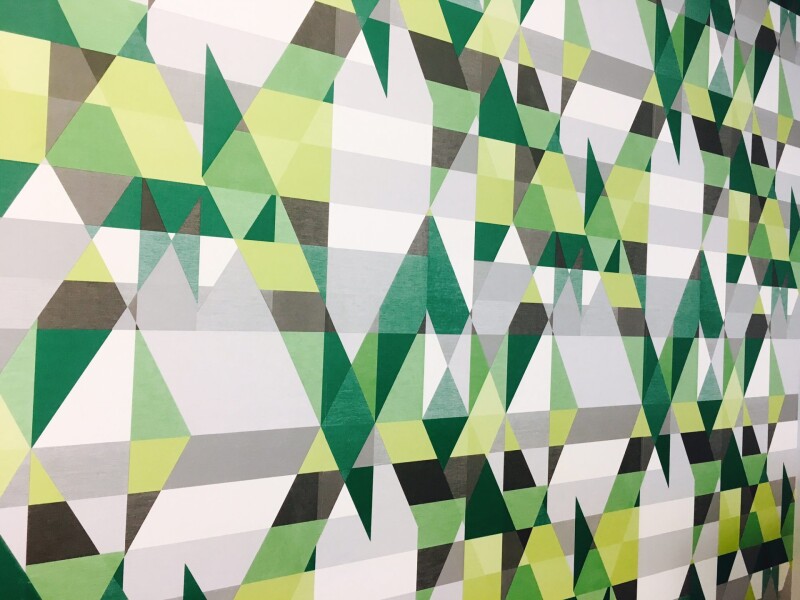 Wallpaper with geometric pattern in green, white, black and grey hues