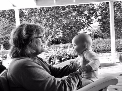 Black and white image, profile view of a grandmother holding her baby grandson, and looking into each others eyes