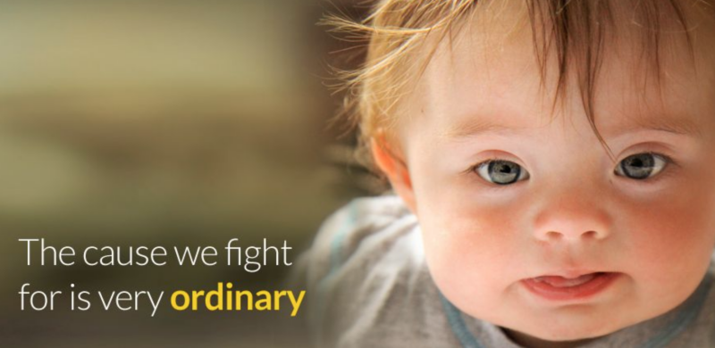 A baby with Down Syndrome on the right of the image, with text on the left saying "The cause we fight for is very ordinary" 