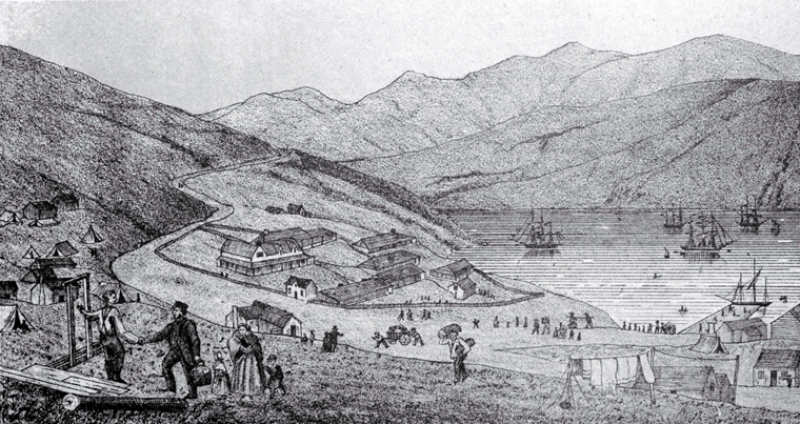 Greyscale drawing of Lyttleton harbour in1850. Banks Peninsula hills in the background, four ships are moored in the water and people and buildings are scattered up the hill in the foreground