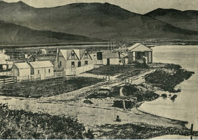 Black and white image of Ferrymead Hotel and Station, 1863. The hotel sits alongside the shoreline with hills in the background