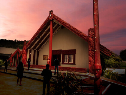 Marae at night with people silhouetted  standing in front